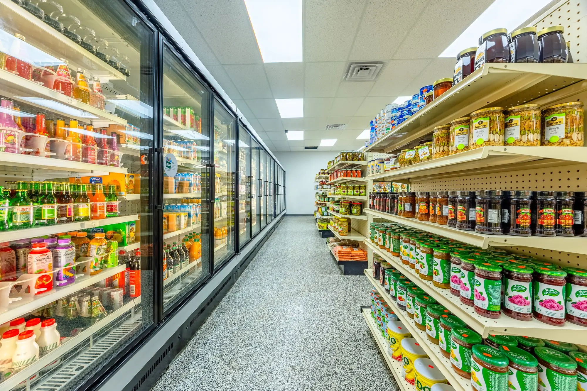 The refrigerated section and the shelves of olives and pickles at ZAMZAM.
