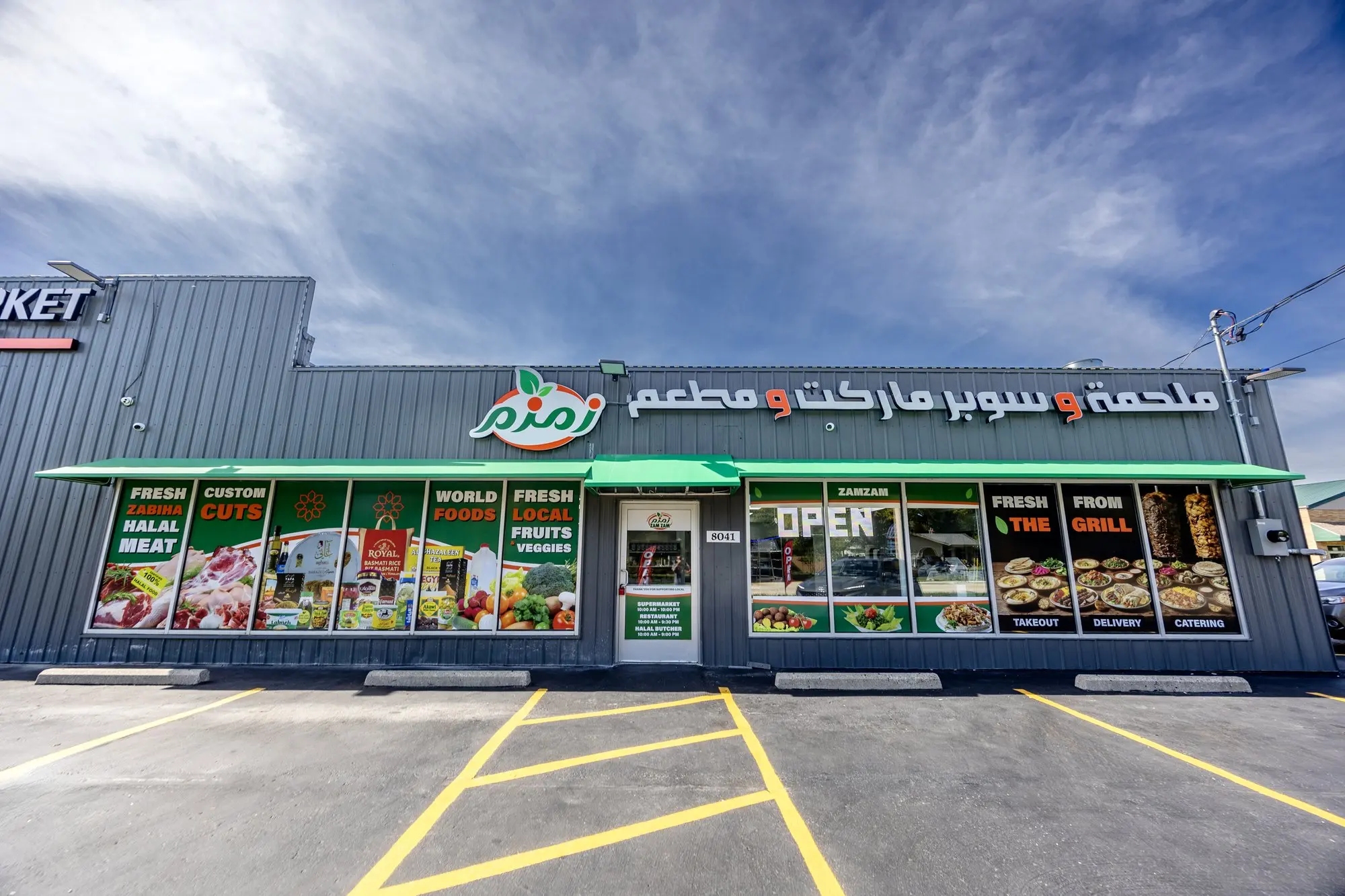The ZAMZAM storefront on South 13th Street in Oak Creek, with the window graphics and the open sign.